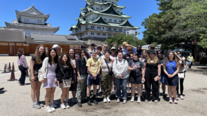 ISU Engineering Study Abroad group stands outside of a building with a Japanese architechtural style in Japan.